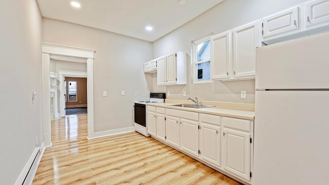 kitchen featuring electric stove, a baseboard radiator, freestanding refrigerator, light wood-type flooring, and a sink