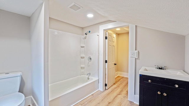 full bath featuring a textured ceiling, bathtub / shower combination, toilet, wood finished floors, and visible vents