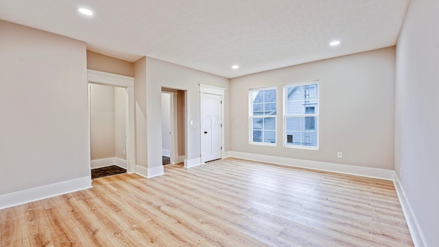 unfurnished bedroom with baseboards, wood finished floors, and recessed lighting