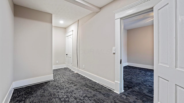 spare room featuring carpet flooring and baseboards