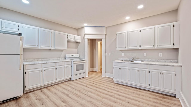 kitchen with light countertops, light wood-style floors, white cabinetry, a sink, and white appliances