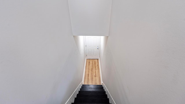 staircase with baseboards and wood finished floors