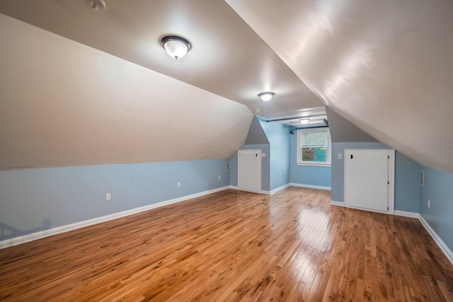 bonus room with wood-type flooring and lofted ceiling