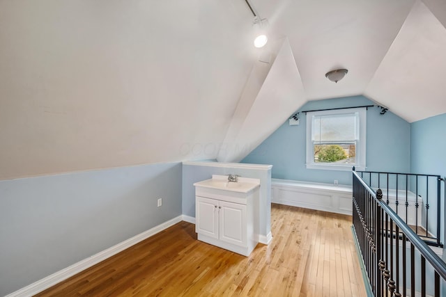 bonus room featuring sink, light hardwood / wood-style floors, and lofted ceiling