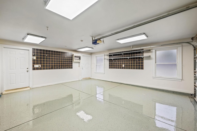 garage with a garage door opener and a wall unit AC