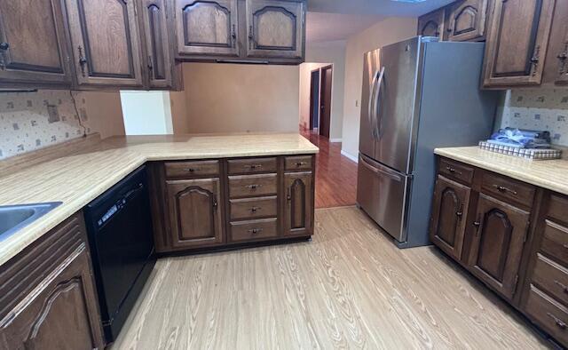 kitchen with dishwasher, dark brown cabinetry, light hardwood / wood-style flooring, and tasteful backsplash