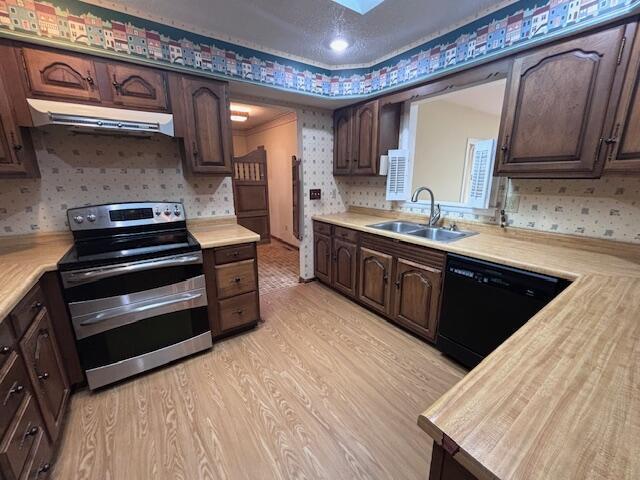 kitchen with sink, black dishwasher, light hardwood / wood-style flooring, range hood, and stainless steel range with electric stovetop