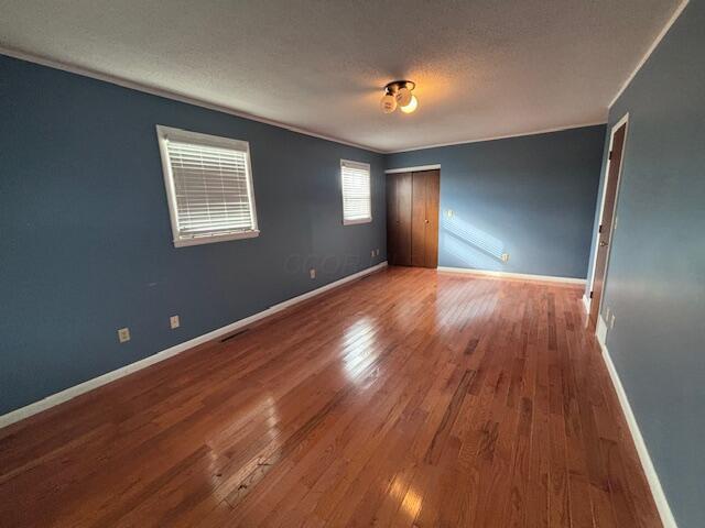 empty room with hardwood / wood-style flooring and a textured ceiling