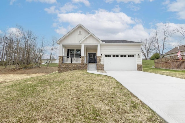 craftsman house featuring a garage, covered porch, a front yard, stone siding, and driveway