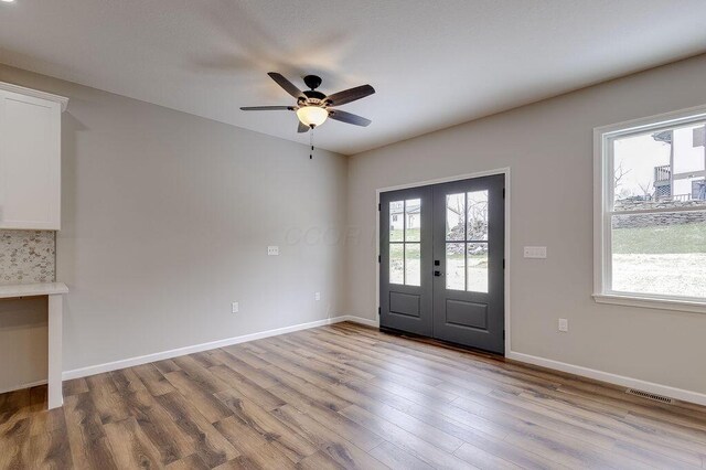 foyer entrance featuring ceiling fan, visible vents, wood finished floors, french doors, and baseboards