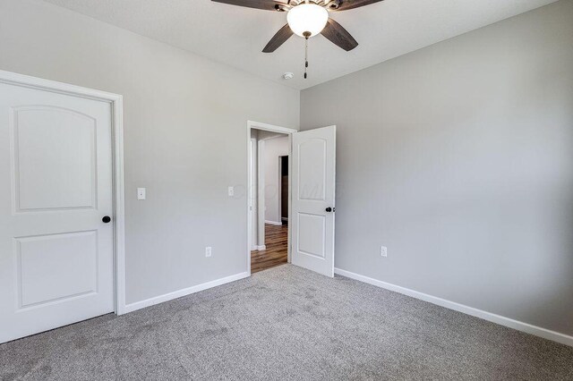 unfurnished bedroom with baseboards, a ceiling fan, and carpet
