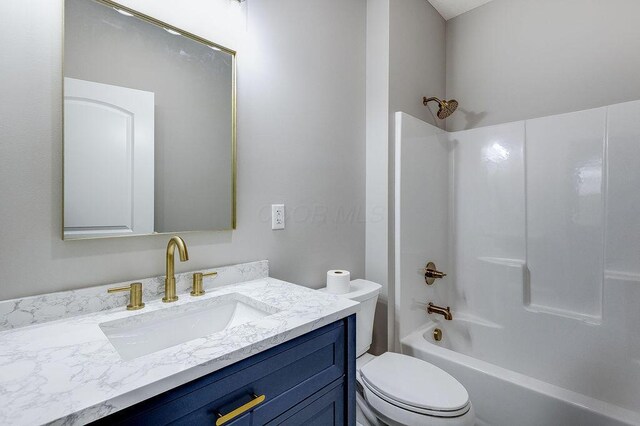 full bathroom featuring toilet, vanity, and  shower combination