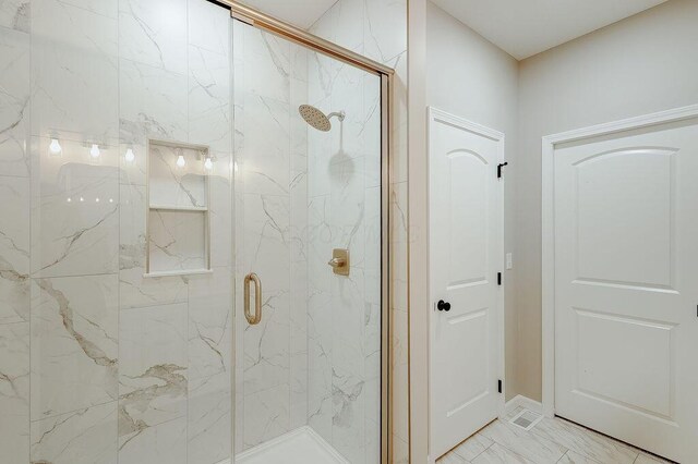 full bath featuring marble finish floor and a marble finish shower