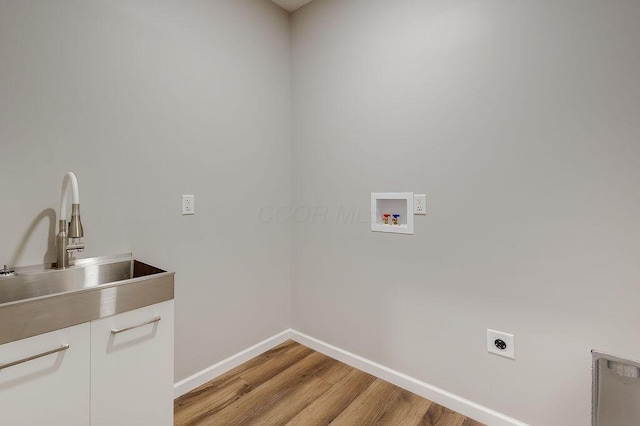 laundry area with electric dryer hookup, light wood-type flooring, washer hookup, a sink, and cabinet space