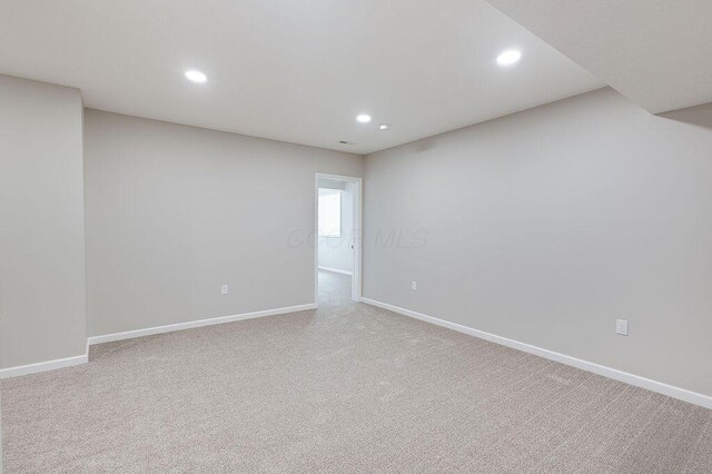 carpeted spare room featuring baseboards and recessed lighting