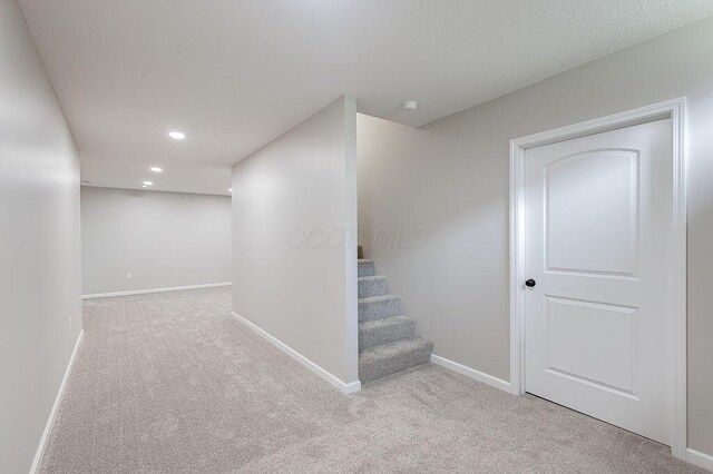 finished basement featuring baseboards, recessed lighting, carpet flooring, and stairway