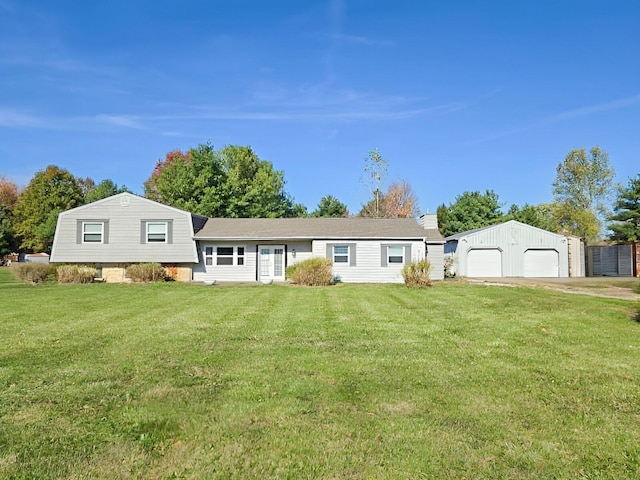 view of front of home with a detached garage, an outbuilding, and a front yard