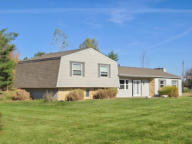 view of front of property featuring roof with shingles, a front lawn, a gambrel roof, and french doors