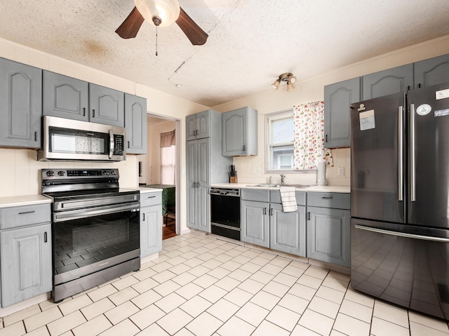 kitchen featuring a textured ceiling, ceiling fan, sink, black appliances, and gray cabinets