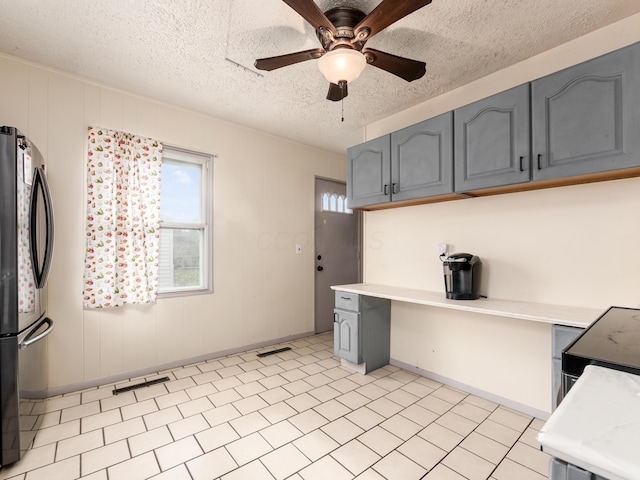 kitchen featuring stainless steel fridge, ceiling fan, gray cabinets, and a textured ceiling