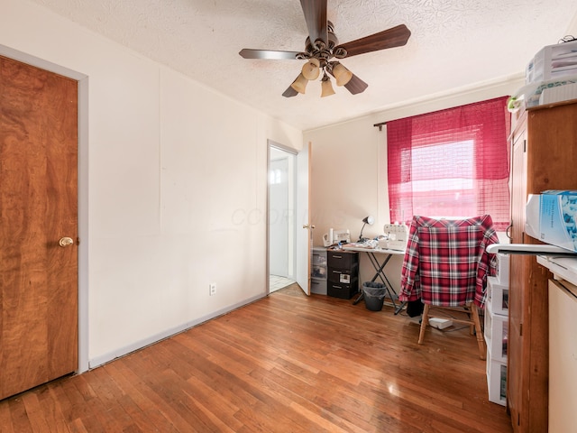 interior space featuring ceiling fan, hardwood / wood-style floors, and a textured ceiling