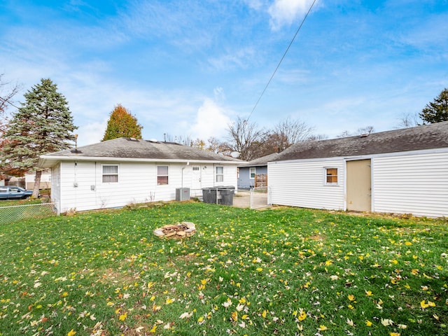 back of property featuring a lawn and central air condition unit