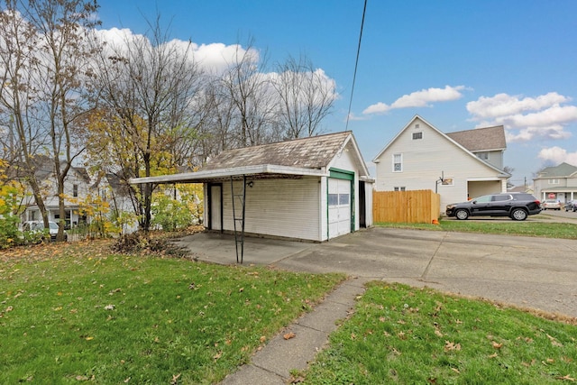 view of outbuilding with a lawn, a garage, and a carport