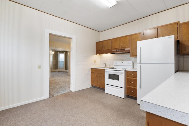 kitchen featuring decorative backsplash, white appliances, light colored carpet, and sink