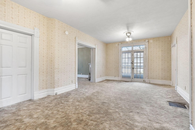 carpeted empty room featuring french doors