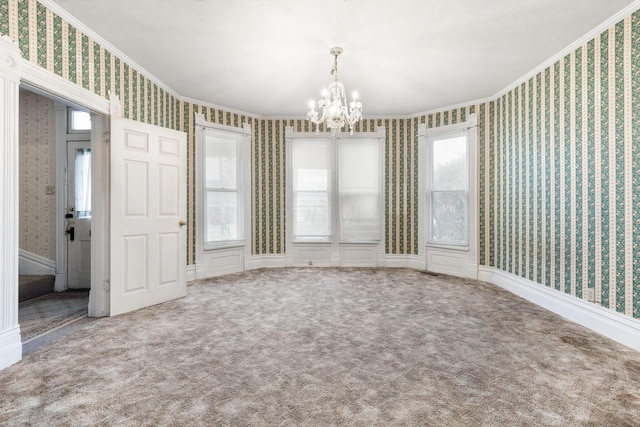 carpeted empty room featuring crown molding and a chandelier