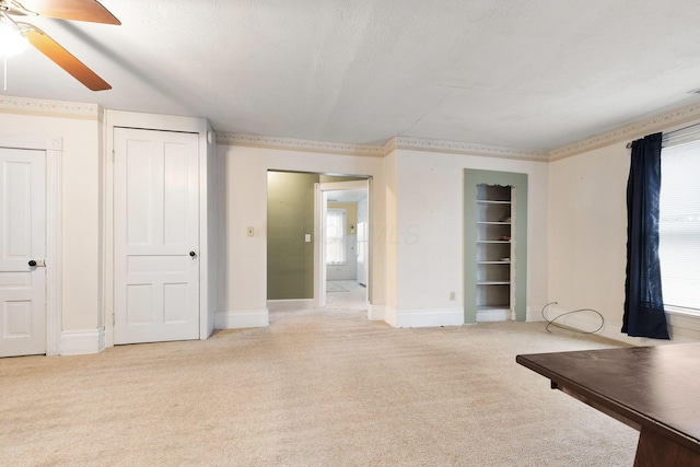 unfurnished living room featuring a textured ceiling, ceiling fan, and light carpet