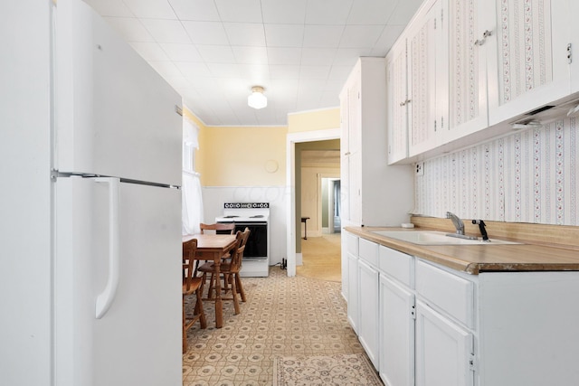 kitchen with white cabinets, white appliances, and sink