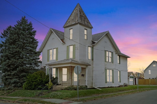 victorian house featuring a lawn, an outdoor structure, and a garage