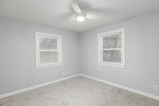 carpeted empty room featuring plenty of natural light and ceiling fan