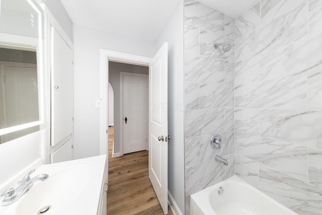 bathroom featuring vanity, hardwood / wood-style flooring, and tiled shower / bath