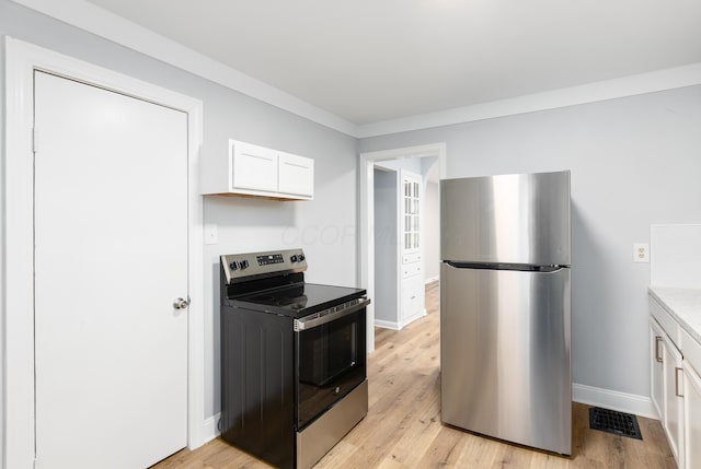 kitchen with stainless steel appliances, white cabinetry, ornamental molding, and light hardwood / wood-style flooring