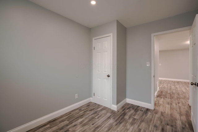 unfurnished bedroom with a closet and dark wood-type flooring