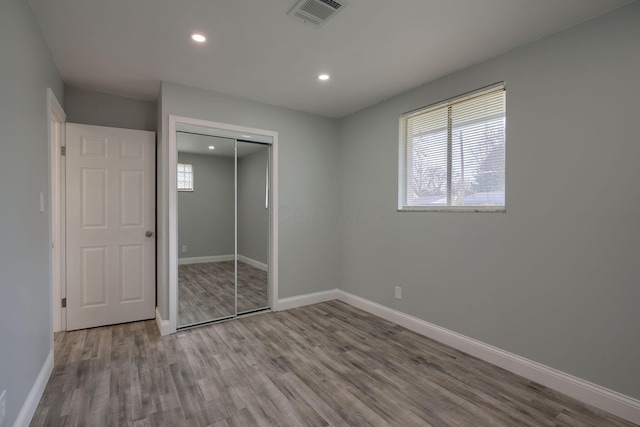 unfurnished bedroom with hardwood / wood-style floors and a closet