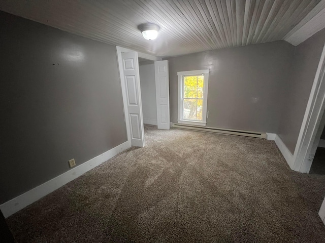 carpeted spare room featuring a baseboard radiator and lofted ceiling