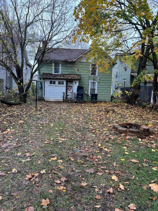 back of property with an outdoor fire pit