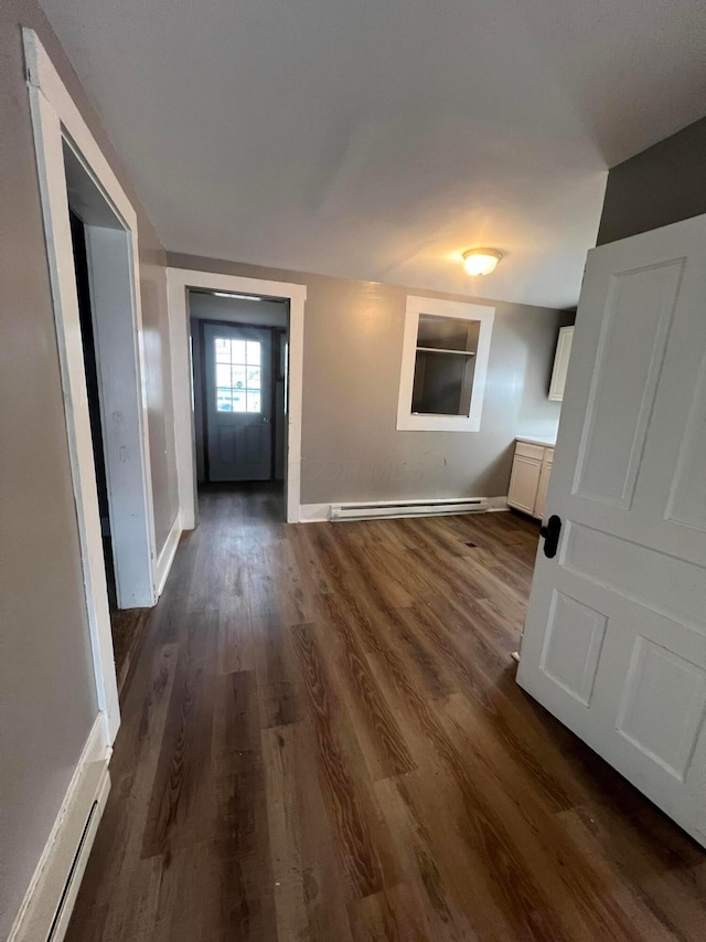 corridor featuring dark hardwood / wood-style flooring and baseboard heating