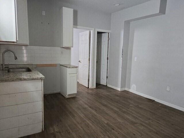 kitchen with dark hardwood / wood-style flooring, decorative backsplash, sink, and white cabinets