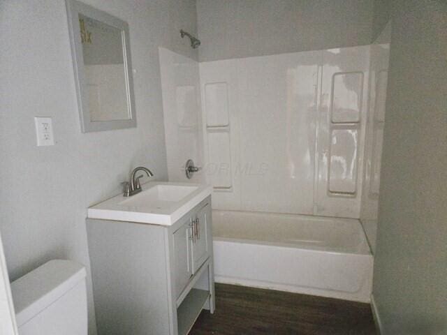 full bathroom with vanity, hardwood / wood-style floors, shower / bathing tub combination, and toilet