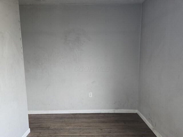 unfurnished room with dark wood-type flooring