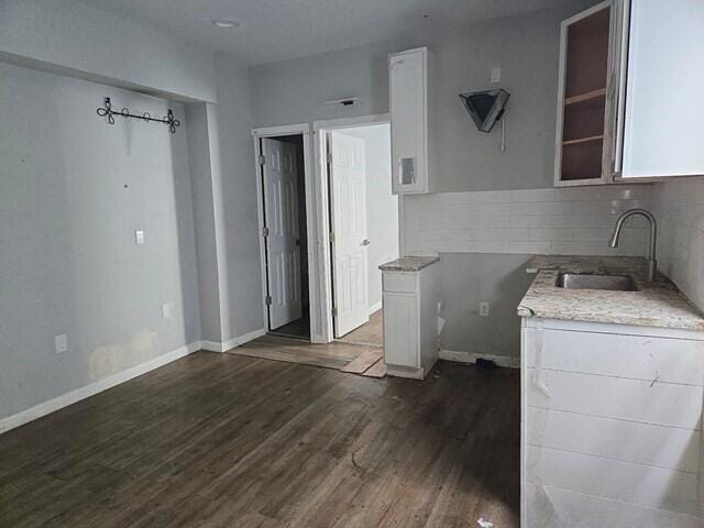 kitchen with dark hardwood / wood-style flooring, white cabinetry, and sink