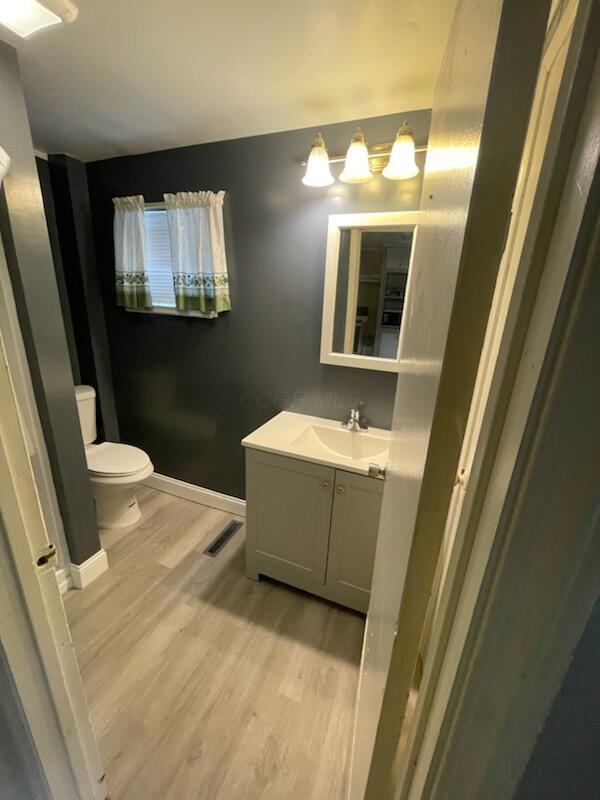 bathroom featuring hardwood / wood-style flooring, vanity, and toilet