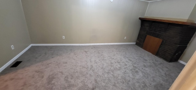 unfurnished living room with carpet and a fireplace