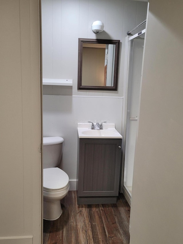 bathroom with walk in shower, vanity, wood-type flooring, and toilet