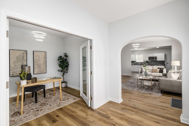 office with a chandelier and light wood-type flooring