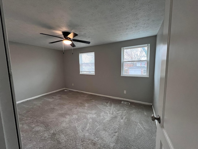 unfurnished room featuring ceiling fan, carpet floors, and a textured ceiling